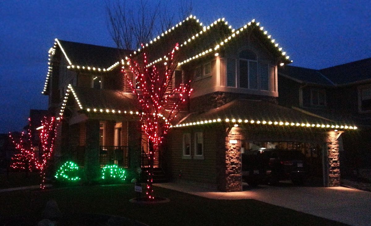 Home with red and green mixed roofline Christmas lighting
