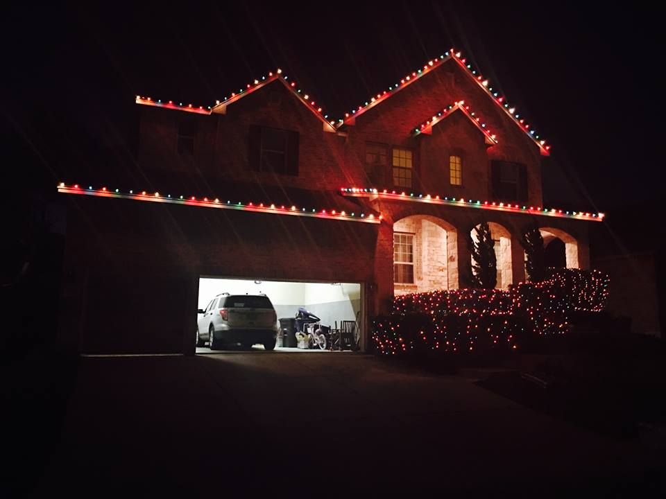Home garage with warm white roofline lighting and a red holiday bow