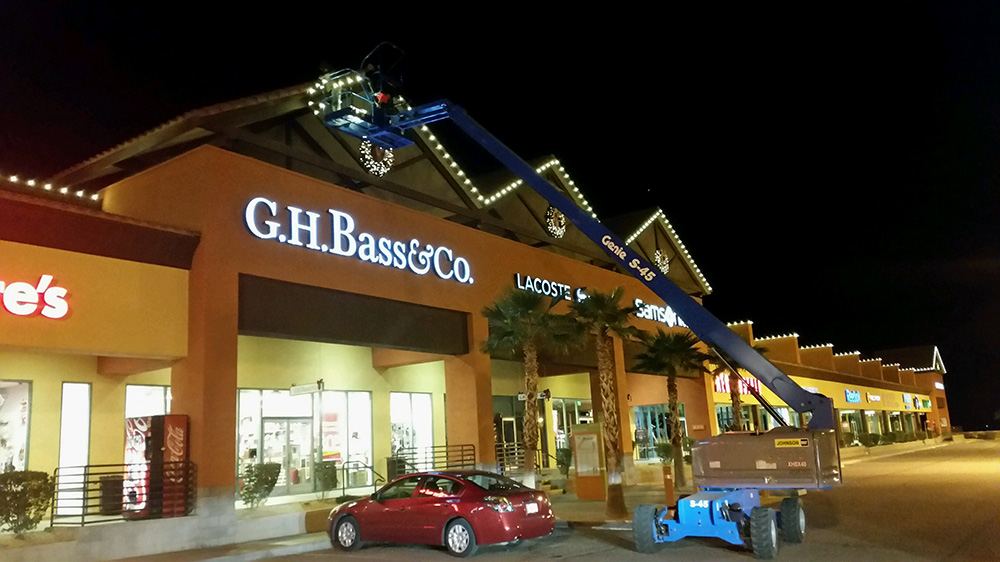 Retail storefront with a crane installing commercial holiday lighting